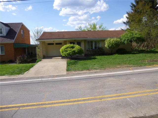 ranch-style home with concrete driveway, a front yard, brick siding, and a garage