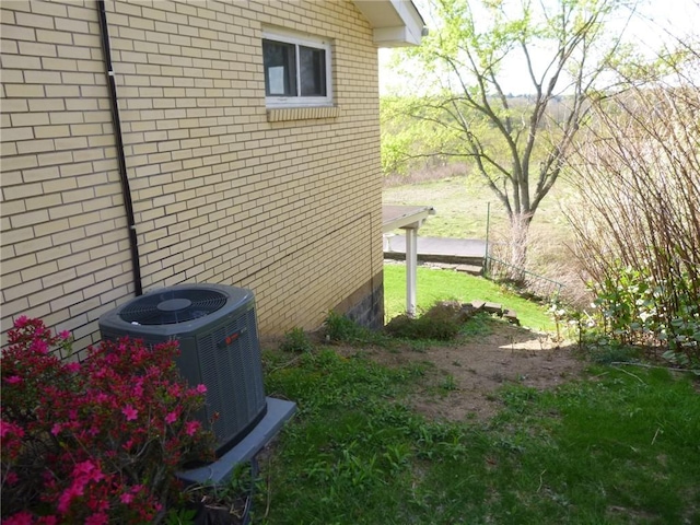 view of side of property with brick siding and central AC unit