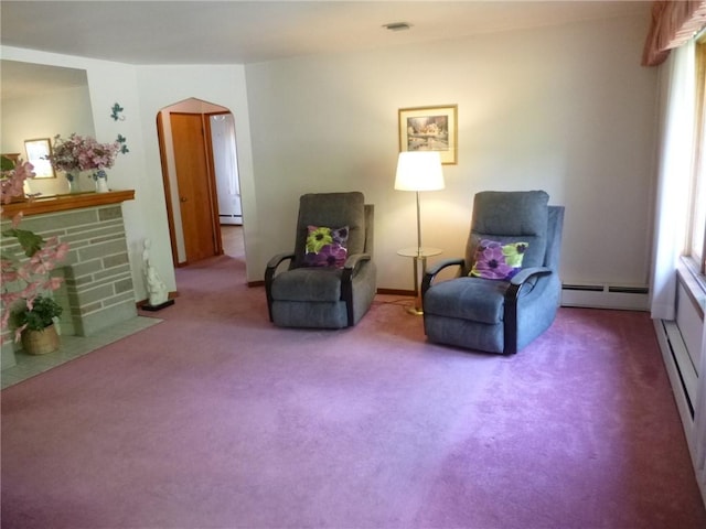 living area with a baseboard radiator, visible vents, baseboard heating, arched walkways, and carpet