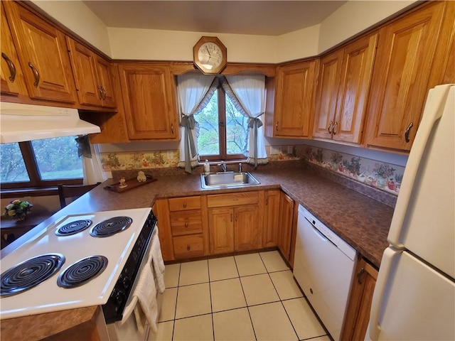 kitchen featuring light tile patterned floors, white appliances, brown cabinetry, and a sink
