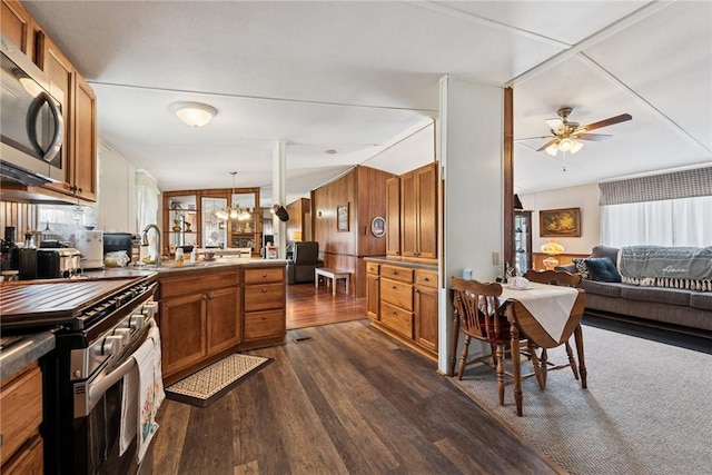 kitchen featuring dark wood finished floors, brown cabinetry, ceiling fan with notable chandelier, a sink, and open floor plan