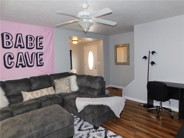 living area with baseboards, wood finished floors, ceiling fan, and a textured ceiling