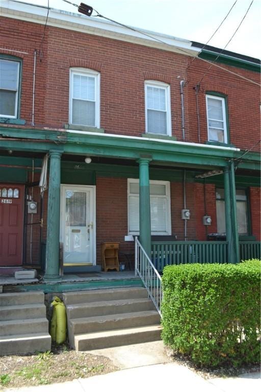 townhome / multi-family property featuring brick siding and a porch