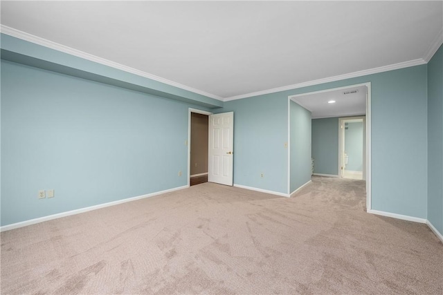 spare room with crown molding, carpet flooring, and baseboards