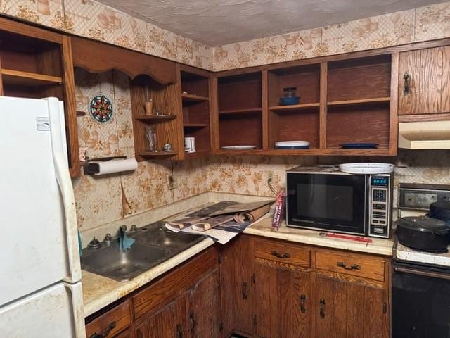 kitchen with black appliances, wallpapered walls, and under cabinet range hood