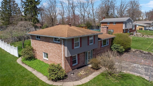 3352 Evergreen Dr, Murrysville, PA 15668 - view of side of home with a chimney, brick siding, fence, and a lawn