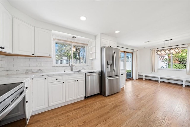 3352 Evergreen Dr, Murrysville, PA 15668 - kitchen featuring light stone countertops, a sink, decorative backsplash, light wood-type flooring, and appliances with stainless steel finishes