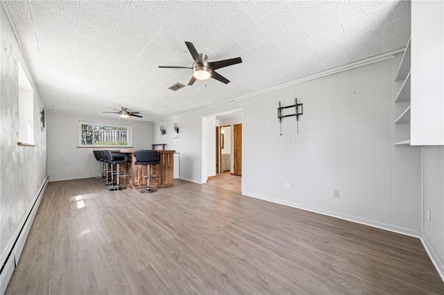 3352 Evergreen Dr, Murrysville, PA 15668 - living room with a ceiling fan, wood finished floors, a baseboard heating unit, and a dry bar