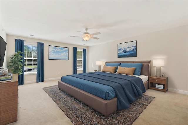 bedroom featuring baseboards, a ceiling fan, and light carpet