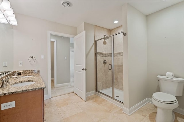 bathroom with baseboards, a shower stall, toilet, and a sink