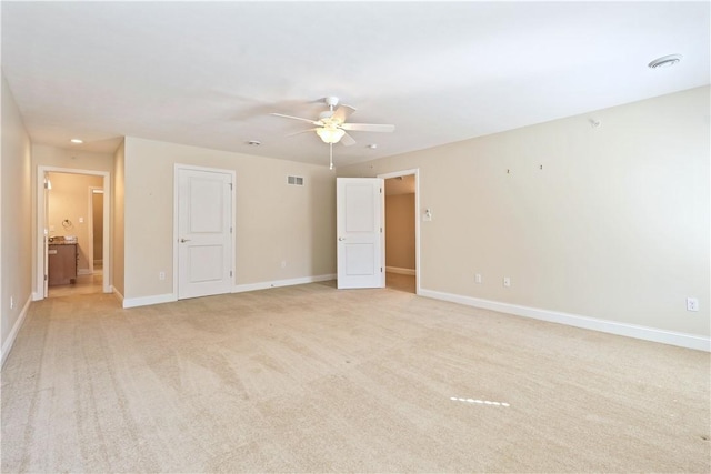 unfurnished bedroom with a ceiling fan, visible vents, light carpet, and baseboards