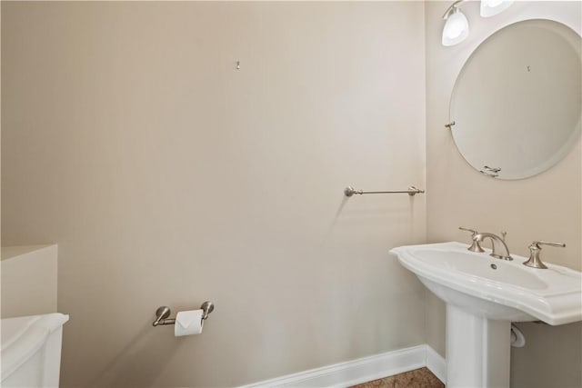bathroom with toilet and baseboards