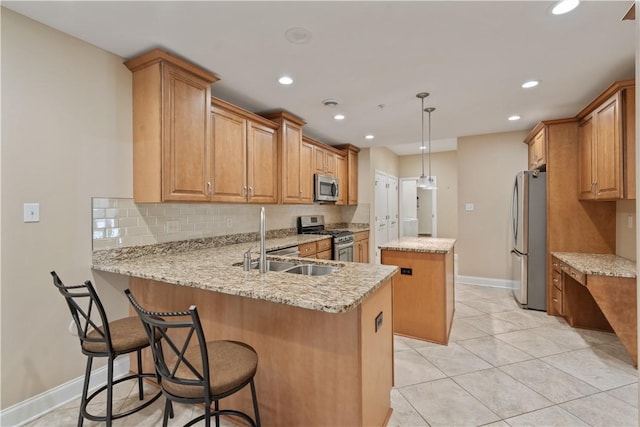 kitchen with decorative backsplash, appliances with stainless steel finishes, a sink, a center island, and a peninsula