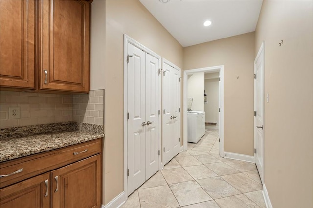corridor featuring baseboards and light tile patterned floors