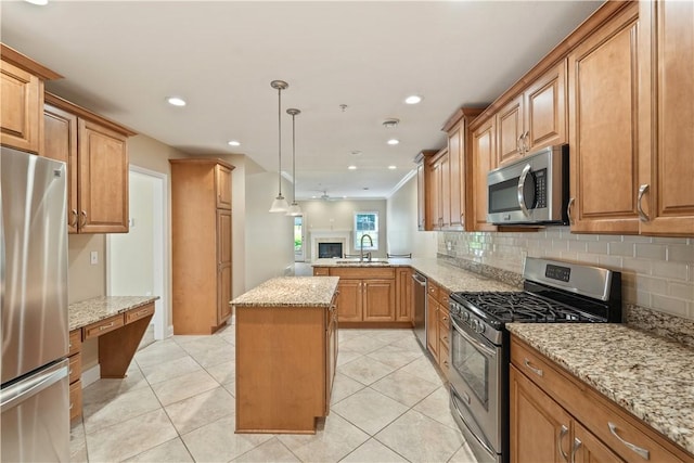 kitchen with stainless steel appliances, backsplash, light stone counters, and a sink