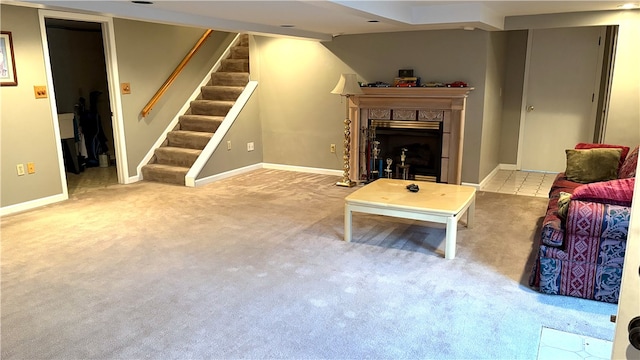 carpeted living area featuring stairs, baseboards, and a fireplace