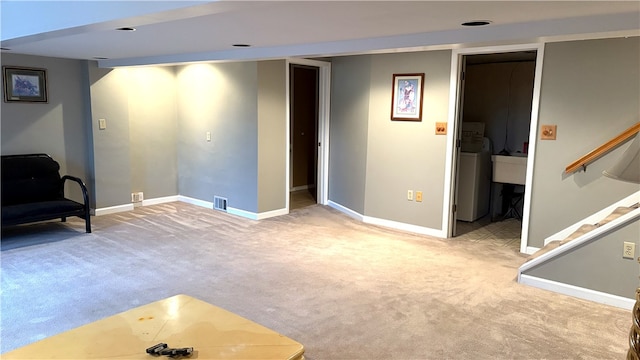 living area with carpet flooring, washer / clothes dryer, baseboards, and stairway