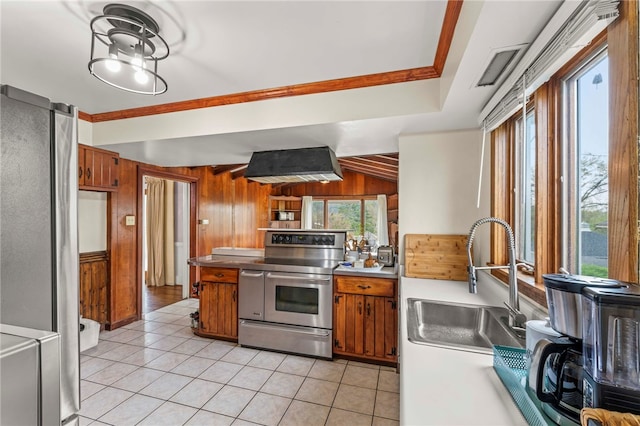 408 N Wade Ave E, Washington Boro, PA 15301 - kitchen featuring light tile patterned floors, range with two ovens, brown cabinetry, wall chimney exhaust hood, and wood walls