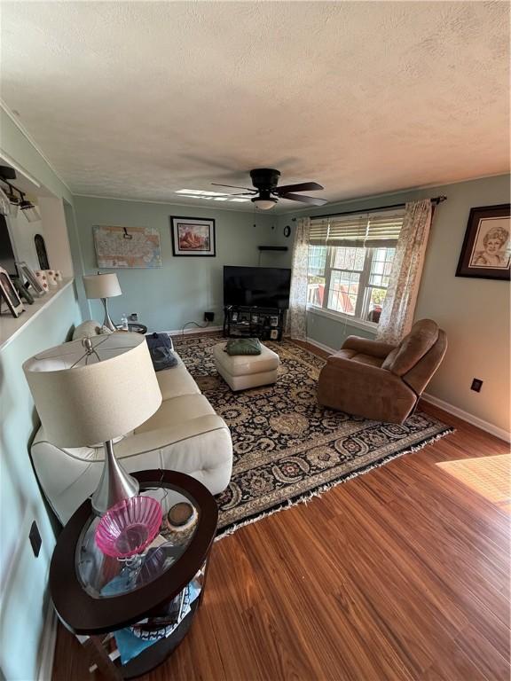 1611 Oneida Valley Rd, Concord Twp, PA 16025 - living area featuring a textured ceiling, ceiling fan, wood finished floors, and baseboards