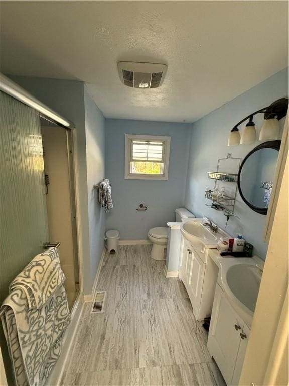1611 Oneida Valley Rd, Concord Twp, PA 16025 - bathroom featuring wood finished floors, toilet, vanity, a stall shower, and a textured ceiling