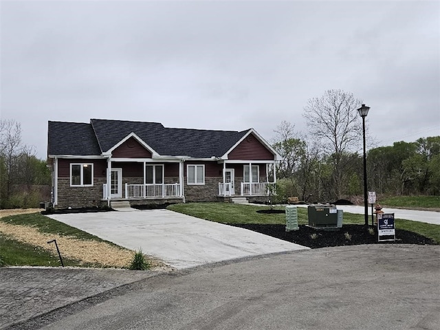 802 Wimbledon Dr, Mount Pleasant Twp Wml, PA 15666 - craftsman-style house with a porch, stone siding, a front yard, and concrete driveway