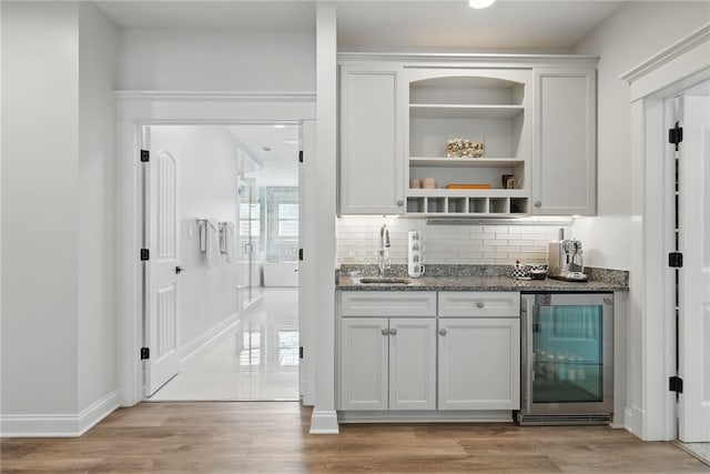 133 Morningside Dr, Cranberry Twp, PA 16066 - bar with beverage cooler, a sink, decorative backsplash, light wood-type flooring, and baseboards