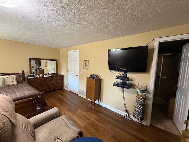 living area featuring baseboards, a textured ceiling, visible vents, and wood finished floors