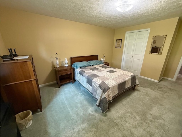 carpeted bedroom featuring baseboards, a closet, and a textured ceiling