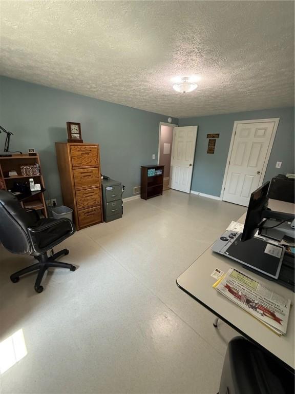 office space featuring baseboards and a textured ceiling