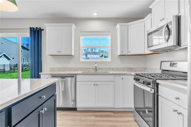 kitchen with recessed lighting, a sink, white cabinets, and appliances with stainless steel finishes