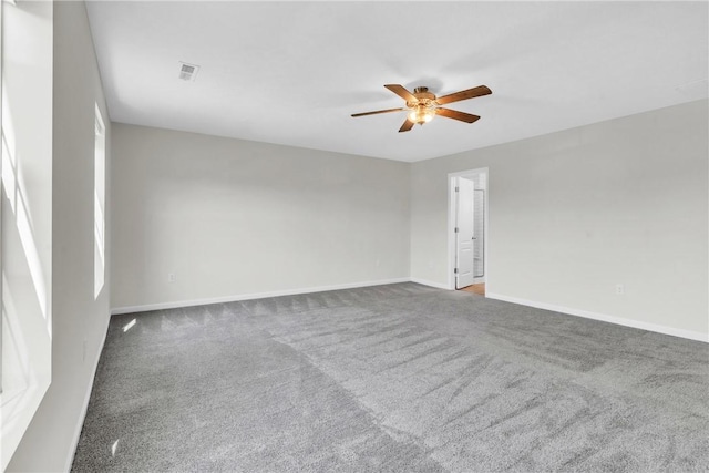 empty room featuring baseboards, visible vents, a ceiling fan, and carpet