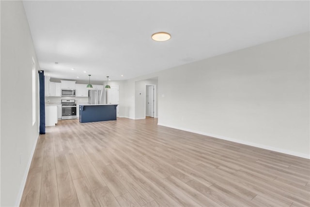 unfurnished living room featuring baseboards, light wood-type flooring, and recessed lighting