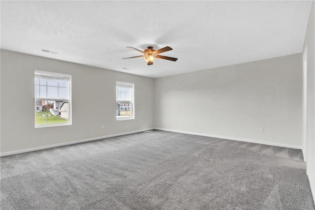 spare room with baseboards, visible vents, ceiling fan, and carpet floors