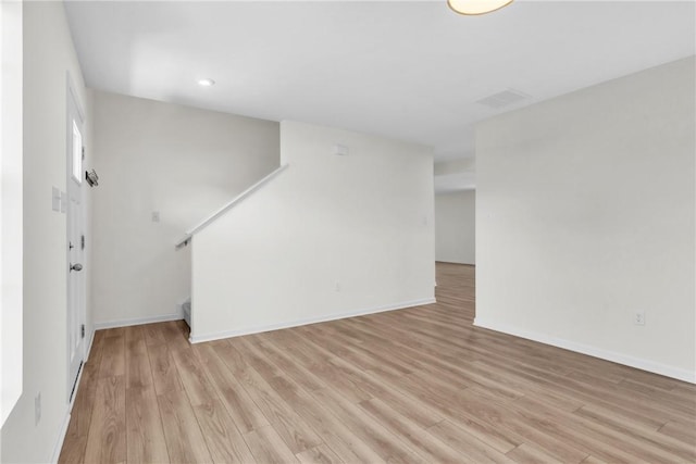 unfurnished living room with recessed lighting, baseboards, and light wood-type flooring