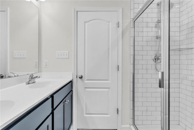 full bathroom featuring a stall shower, double vanity, and a sink