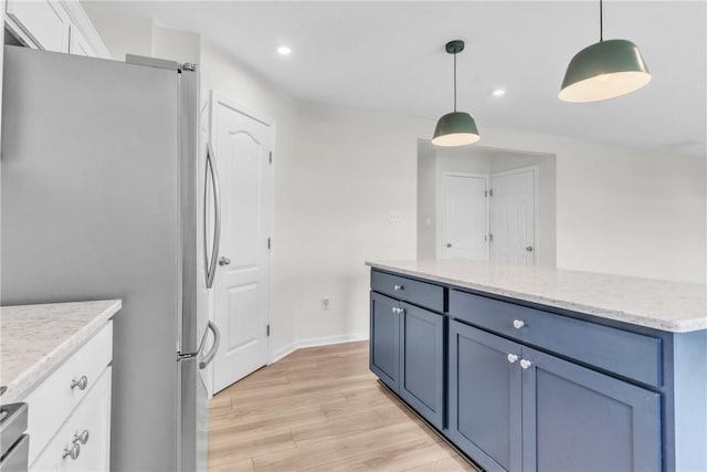 kitchen featuring recessed lighting, light wood-style flooring, white cabinetry, hanging light fixtures, and freestanding refrigerator
