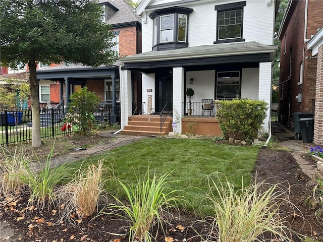 view of front facade with fence, a porch, a front lawn, and brick siding