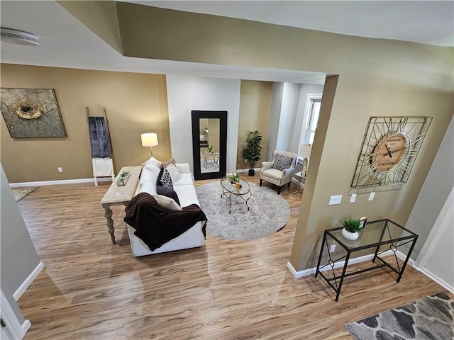 living area with baseboards and wood finished floors