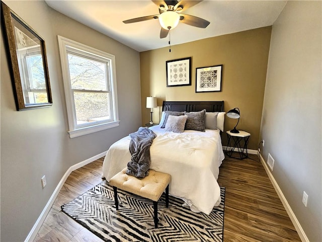 bedroom with baseboards, wood finished floors, and visible vents