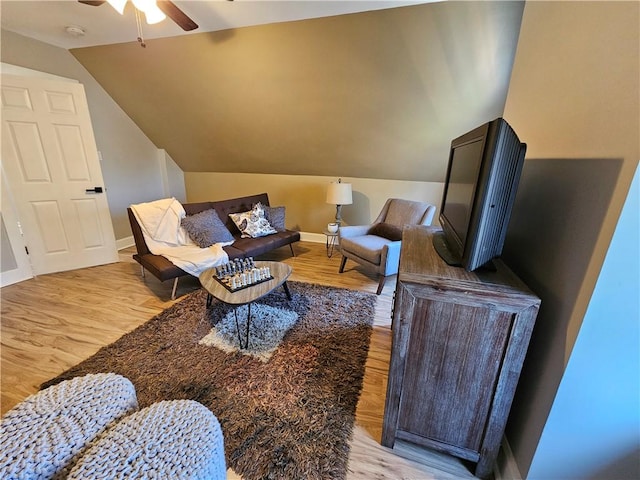 living room with light wood finished floors, ceiling fan, and vaulted ceiling