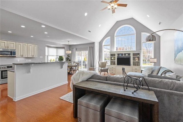 living area featuring recessed lighting, high vaulted ceiling, a ceiling fan, visible vents, and light wood-style flooring