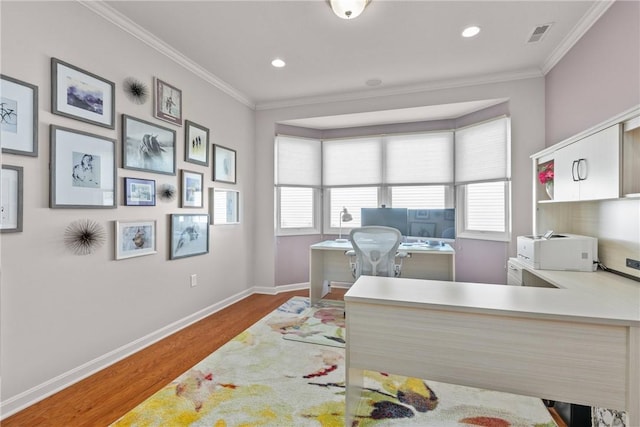office area with baseboards, wood finished floors, crown molding, and plenty of natural light