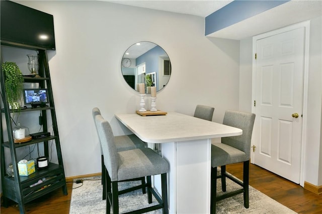 dining area with dark wood finished floors and baseboards