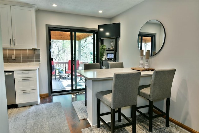 dining room featuring recessed lighting, dark wood-style flooring, and baseboards