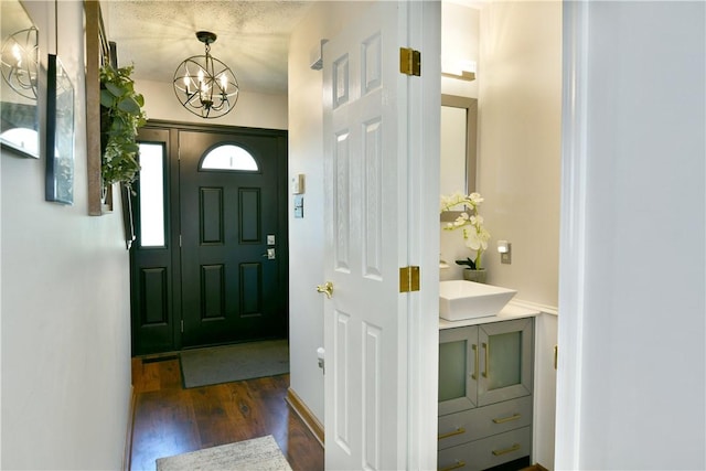 entrance foyer with an inviting chandelier and dark wood-style flooring