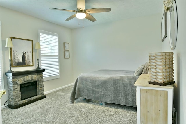 carpeted bedroom featuring a fireplace, ceiling fan, and baseboards