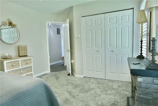 carpeted bedroom with a closet and baseboards