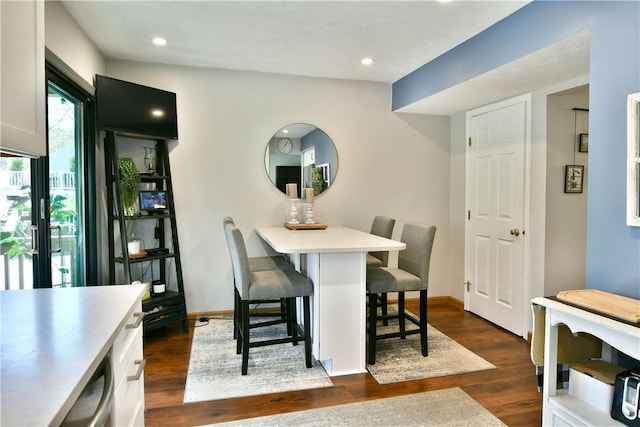 dining room with recessed lighting, baseboards, and dark wood-type flooring