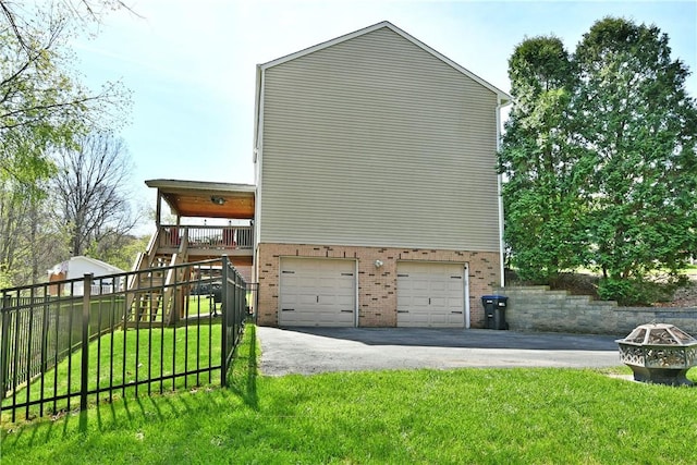 view of side of property featuring a lawn, stairway, an attached garage, and brick siding