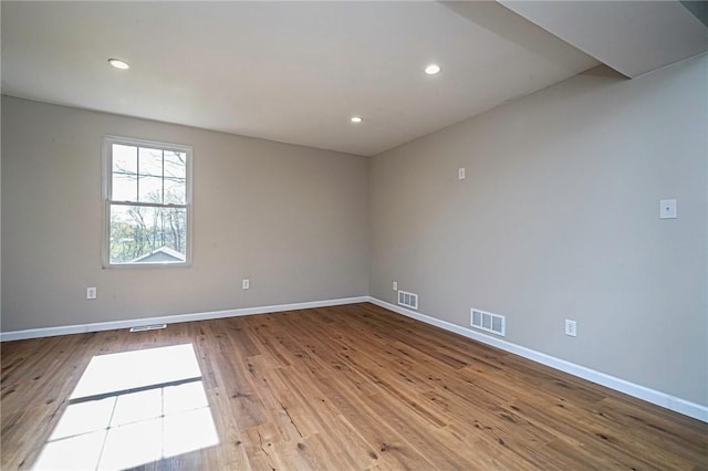 spare room with recessed lighting, visible vents, wood finished floors, and baseboards